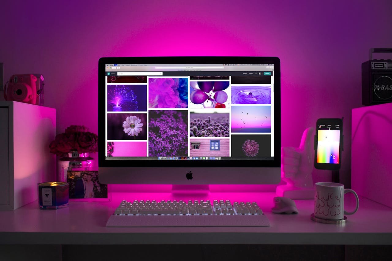 services-03 Modern desk setup with neon lighting and a desktop computer displaying colorful images.